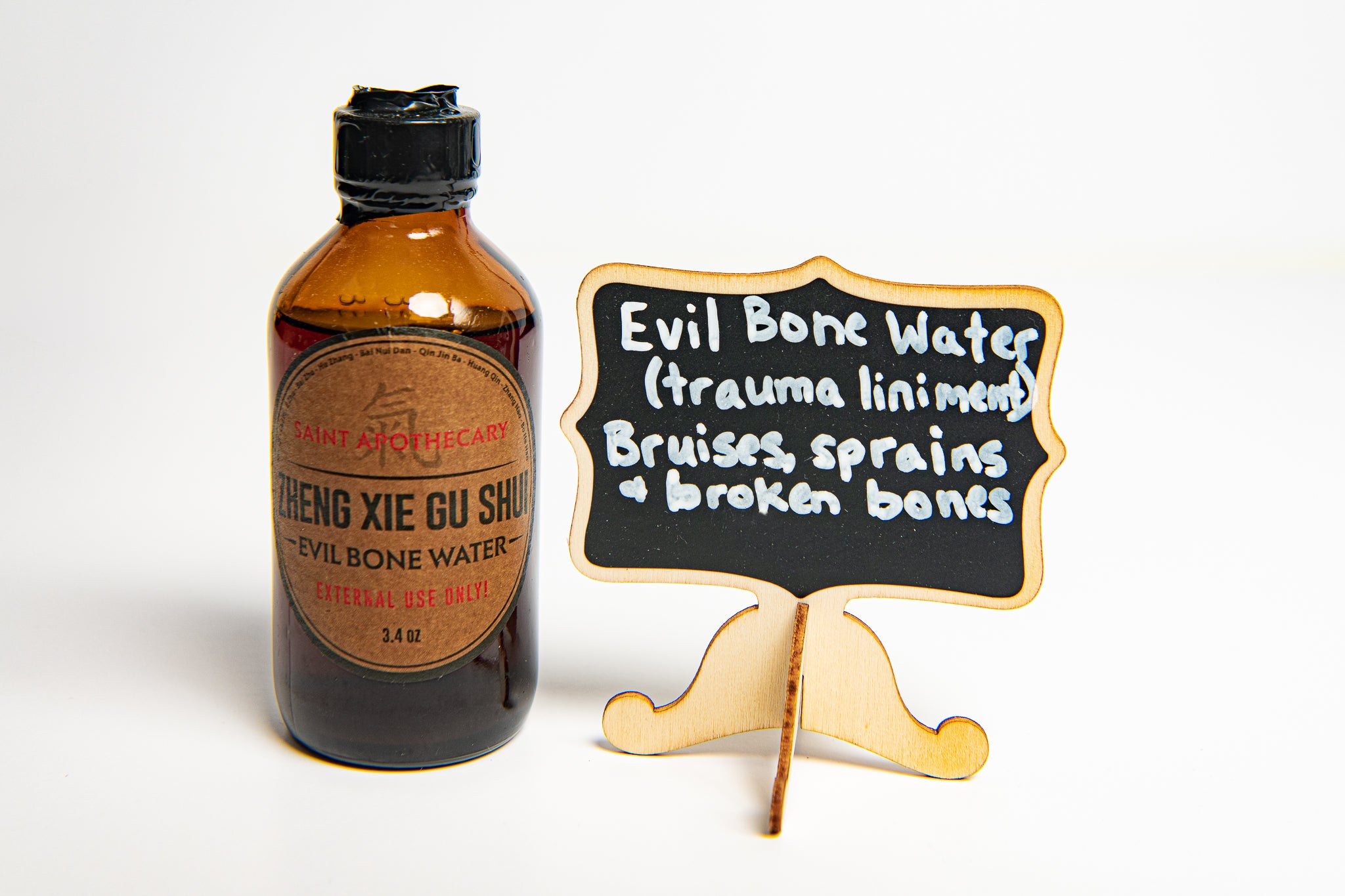 Evil Bone Water Photo with sign that says trauma liniment, bruises, sprains and broken bones, photo credit by Laura Orozco Photography